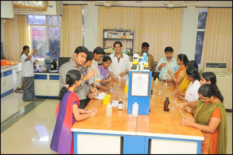A group gathered around a laboratory workbench